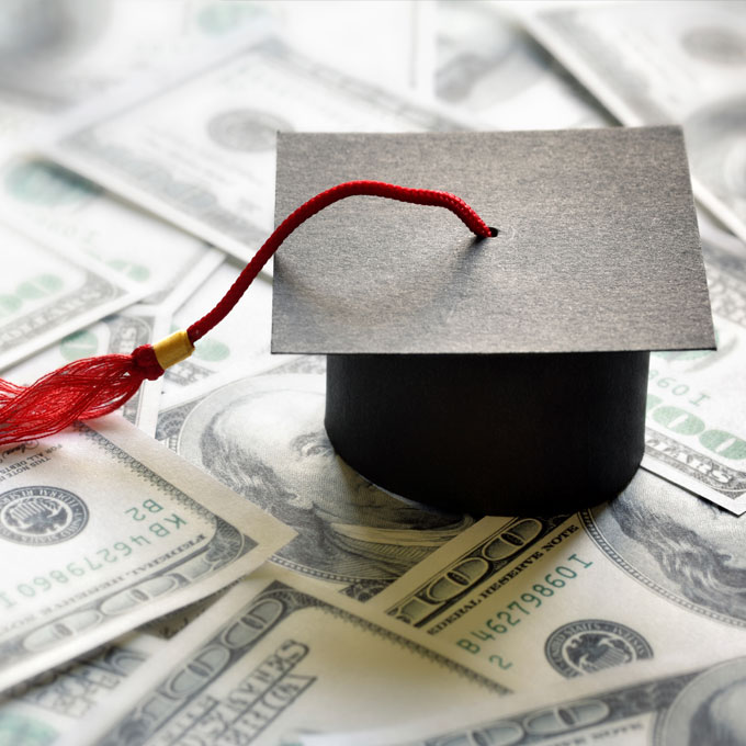 Photo of a graduation hat sitting on top of money